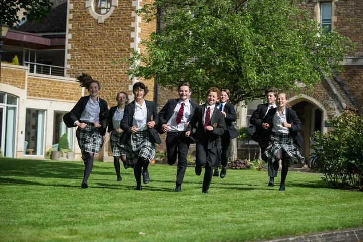 Students running across the lawn
