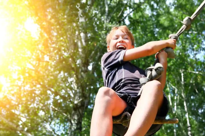 Boy on a rope swing in the woods